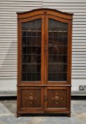 Early 20th century oak bookcase, the domed top over two leaded glazed doors opening to three