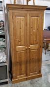 Modern pine wardrobe, the two panel doors opening to an empty space, on a plinth base, 187cm high