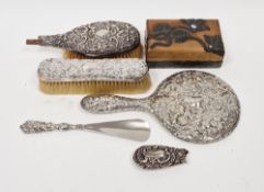 Silver-backed dressing table hand mirror decorated with scrolls and flowerheads, a silver-backed