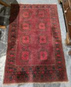 Eastern red ground rug with two rows of four hooked geometric medallions, multiple geometric