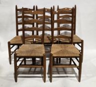 Set of five pale oak ladderback Shaker-style dining chairs with rush seats, on turned legs united by