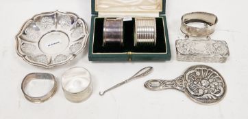 Three various silver napkin rings, one plated napkin ring, miniature hand mirror, embossed and