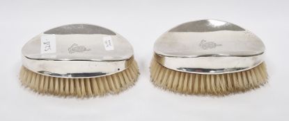 Pair of Edwardian silver-backed brushes by William Comyns & Sons, London 1908, of oval form engraved