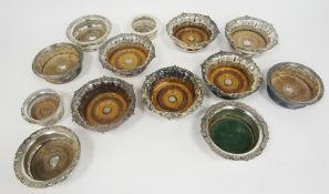 Set of six silver plated wine coasters of circular form, the rims with shell and scroll decoration