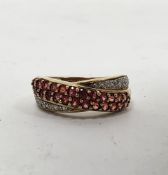 Gold gem set ring of crossover design set with orange sapphires and tiny diamonds, marked 375,