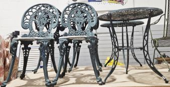 Ornate garden aluminium table and two chair set in the Victorian manner, with a green finish,