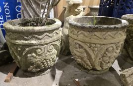 Four reconstituted stone planters of circular section, each decorated with geometric patterns,