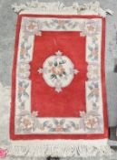 Chinese red ground superwash rug with central floral medallion, single floral border, 99cm x 62cm