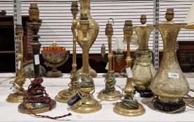 Pair of Indian-style brass embossed table lamps, five further brass table lamps and an ebonised