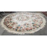 Large cream ground circular Chinese superwash wool carpet with central floral motif and single