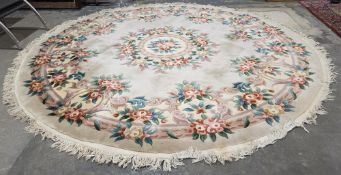 Large cream ground circular Chinese superwash wool carpet with central floral motif and single