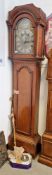 19th century oak longcase clock, the arched hood with tapered columns, holding a brass arched dial