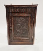 19th century oak corner cabinet in the 17th century-style, the single panel door carved with a Tudor