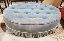 Early 20th century ottoman stool of oval form having blue button top upholstery and a bullion