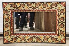 Rectangular wall mirror, the black stained frame with carved foliate and floral scroll decoration,