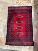 Eastern red ground rug with four central hooked elephant foot guls, multiple geometric borders