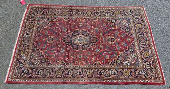 Eastern red ground rug with central floral motif on floral field and spandrels, multiple floral