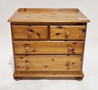 Modern pine chest comprising two short over two long drawers with pine knob handles, on bun feet,