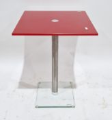 Contemporary red glass topped side table of square form by Helderr, on a chrome pedestal support and