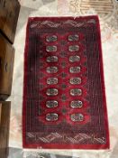 Eastern red ground rug with two rows of eight elephant foot guls surrounded by geometric medallions,