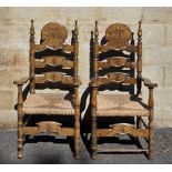 Pair of 20th century Spanish-style walnut carver chairs, the ladder backs with carved starburst