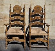 Pair of 20th century Spanish-style walnut carver chairs, the ladder backs with carved starburst