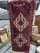 Eastern red ground runner with two large lozenge medallions on lozenge pattern grid, single