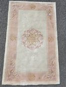 Cream ground Chinese superwash rug with central floral motif, single floral border, 150cm x 92cm
