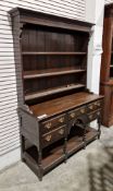 George III oak dresser, the panel back upper section with three plate shelves, the lower section
