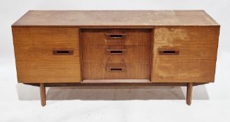 Mid-century teak sideboard comprising three central drawers flanked either side by cupboard doors,