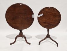 Two early 19th century mahogany supper tables, with circular tilt tops, the largest with a fluted