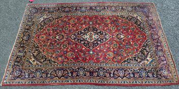 Eastern red ground rug with central floral motif on floral field and spandrels, multiple floral