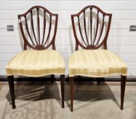 Pair of mahogany dining chairs in the Hepplewhite manner with shield shaped backs, upholstered