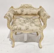 A cream distressed painted fauteuil in the Louis XV style with foliate scroll carved back rail and