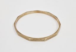 9ct yellow gold bangle, the outer edge of hendecagon form, having a Greek key engraved pattern,
