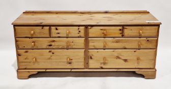 Modern large pine chest comprising a bank of seven drawers with pine knob handles, on bracket-