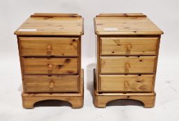 Pair of modern pine bedside chests, each with three short drawers, pine knob handles, on bracket-