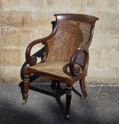 Regency mahogany and bergere library chair, the top rail with carved scroll ends, foliate scroll