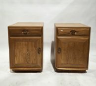 Pair of Ercol light elm Windsor bedside cabinets, each with single drawer over cupboard door, each