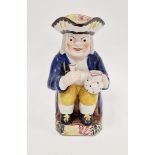 English pottery toby jug, circa 1820-40, modelled seated holding a jug and goblet, pierced hat and