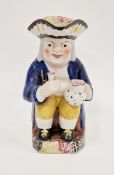 English pottery toby jug, circa 1820-40, modelled seated holding a jug and goblet, pierced hat and