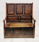 18th century oak box settle, the high panel back over a seat with hinged lift lid, two open shaped