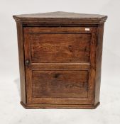 George III oak hanging corner cupboard, the single panel door opening to a painted interior with two