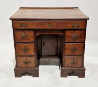 Mahogany kneehole desk in the George III manner, the rectangular top over an arrangement of seven