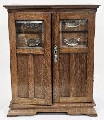 Victorian oak smoker's cabinet, the glazed and panel twin doors opening to four small drawers,