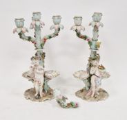 Pair of German porcelain (Volkstedt) flower-encrusted figural four branch candelabra, circa 1880,
