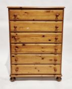 Modern pine chest of six long drawers with pine knob handles and bun feet, 121cm high x 87cm wide