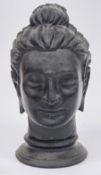 Gandharan style patinated bronze bust of Buddha, on an ebonised wooden plinth, 32cm high