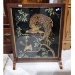 Early 20th century oak framed firescreen having a needlework panel decorated with exotic birds