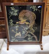 Early 20th century oak framed firescreen having a needlework panel decorated with exotic birds